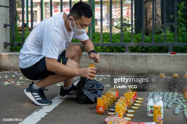 Man lays bottled yellow peach outside No.34 Middle School to mourn for victims of gym roof collapse on July 25, 2023 in Qiqihar, Heilongjiang...