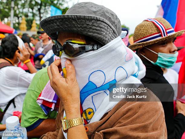 Man tries to clear tear gas from his eyes after Thai police used gas during a large anti government protest on November 24, 2012 in Bangkok,...