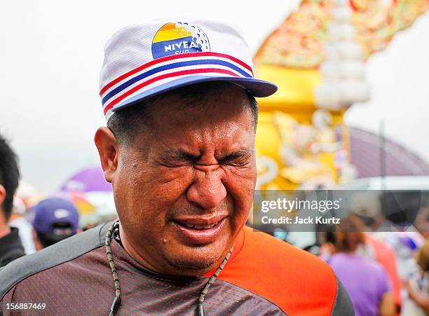 Man tries to clear tear gas from his eyes after Thai police used gas during a large anti government protest on November 24, 2012 in Bangkok,...