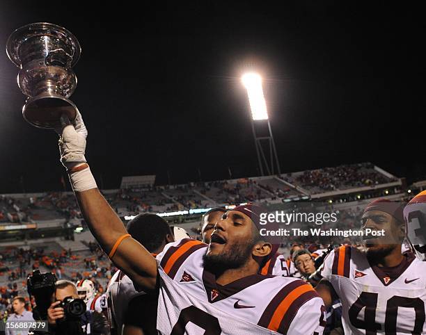 November 26: Virginia Tech Hokies cornerback Cris Hill holds aloft the Commonwealth Cup after defeating the Virginia Cavaliers during the game at the...
