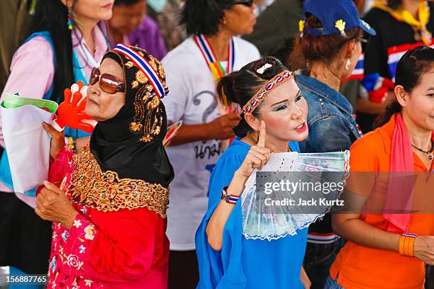 People in the crowd dance and wave Thai flags during a large anti government protest on November 24, 2012 in Bangkok, Thailand. The Siam Pitak group,...