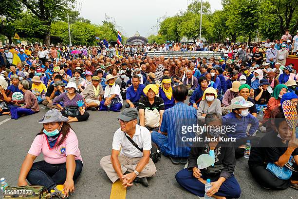 Protesters and Buddhist monks sit on the ground in front of riot police during a large anti government protest on November 24, 2012 in Bangkok,...