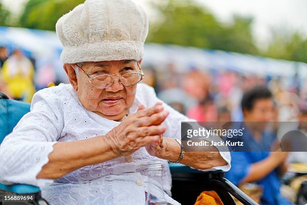 Woman prays for Gen Boonlert "Seh Ai" Kaewprasit, leader of Pitak Siam, speaks during a large anti government protest on November 24, 2012 in...