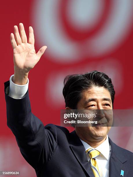 Shinzo Abe, Japan's former prime minister and president of the Liberal Democratic Party , waves during a campaign rally for the Dec. 16 general...