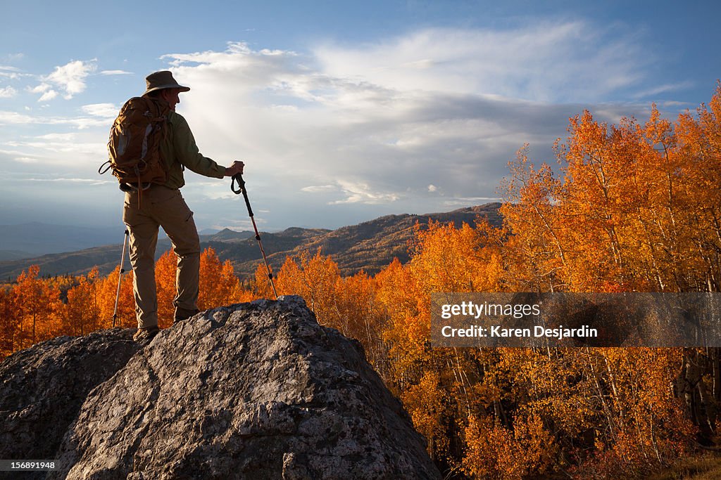 A hiker on a rock with autumn landscape, Colorado
