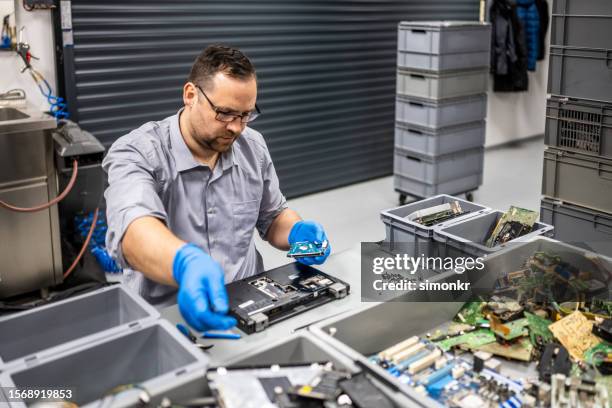 hombre reparando portátil - componente de ordenador fotografías e imágenes de stock
