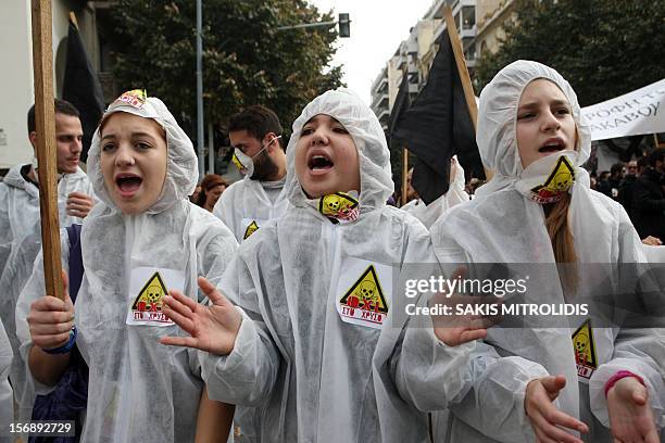 Girls wearing Chemical Protective Suits shout slogans as they march in Thessaloniki on November 24 during a protest against efforts by Hellenic Gold,...