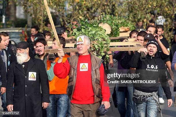 Demonstrators, carrying cut trees, march in Thessaloniki on 24 November, 2012 against efforts by Hellas, a subsidiary of the Canadian firm Eldorado...