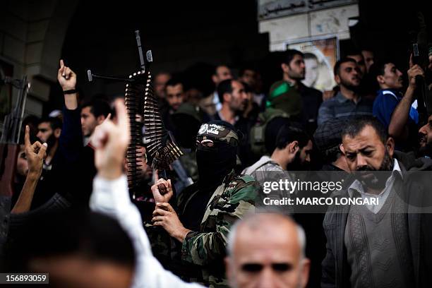 Palestinian militants of Hamas' armed wing, the Ezzedine al-Qassam Brigades, attend the funeral procession of one of their leaders, Judah Shamallah,...