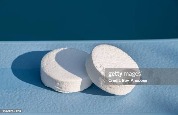 chlorine tablets on the poolside of swimming pool. - chlorine stock pictures, royalty-free photos & images