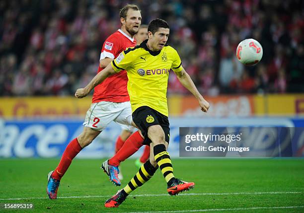 Robert Lewandowski of Dortmund scores his team's second goal next to Bo Svensson of Mainz during the Bundesliga match between 1. FSV Mainz 05 and...