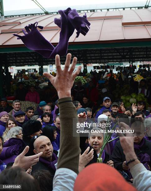 Dan Diaconescu the president of Dan Diaconescu Popular Party throws a purple scarf to his supporters during an electoral meeting in Targu Jiu city...