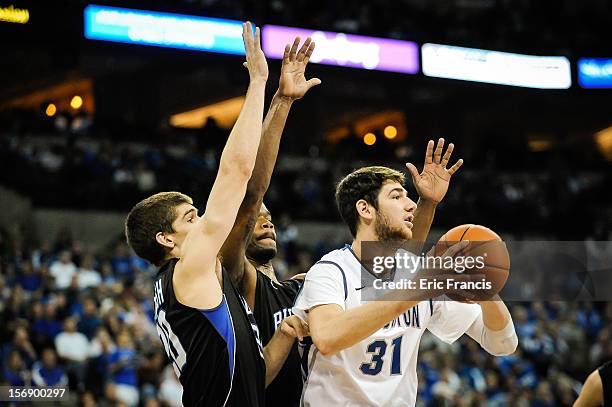 Will Artino of the Creighton Bluejays is guarded by Ryan McTavish and Joshua Clyburn of the Presbyterian Blue Hose during their game at CenturyLink...