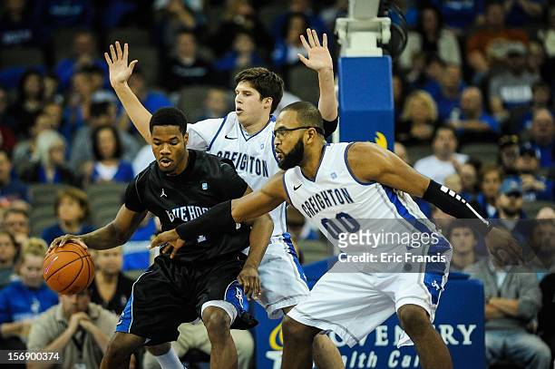 Doug McDermott and Gregory Echenique of the Creighton Bluejays guard Joshua Clyburn of the Presbyterian Blue Hose during their game at CenturyLink...