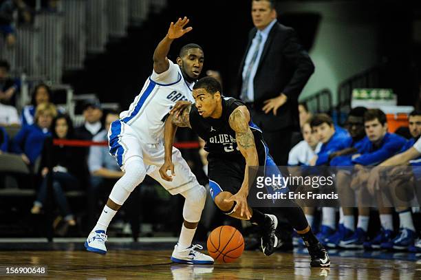 Jordan Downing of the Presbyterian Blue Hose works his way around Jahenns Manigat of the Creighton Bluejays during their game at CenturyLink Center...