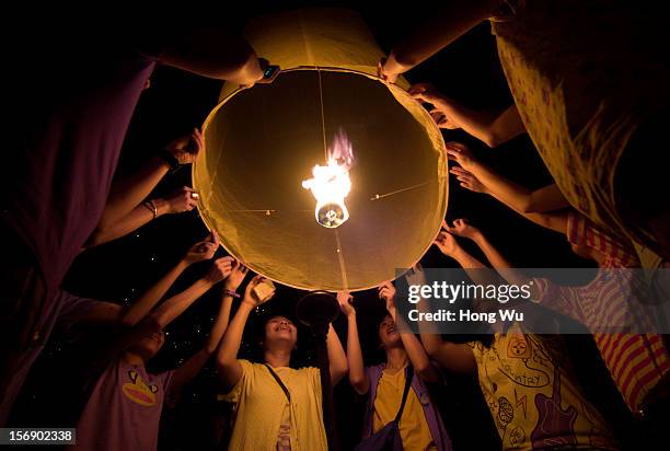 Thai people launch khom loi into the night sky during the Yi Peng Festival on November 24, 2012 in Chiang Mai, Thailand. The Yi Peng Festival is a...