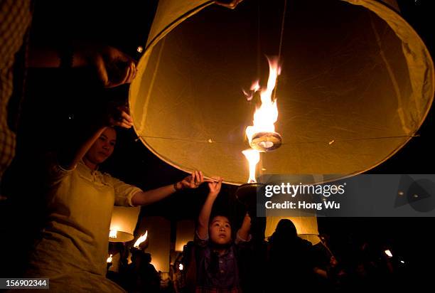 Thai people launch khom loi into the night sky during the Yi Peng Festival on November 24, 2012 in Chiang Mai, Thailand. The Yi Peng Festival is a...