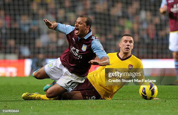 Lukas Podolski of Arsenal tackles Aston Villa's Gabriel Agbonlahor during the Barclays Premier League match between Aston Villa and Arsenal at Villa...