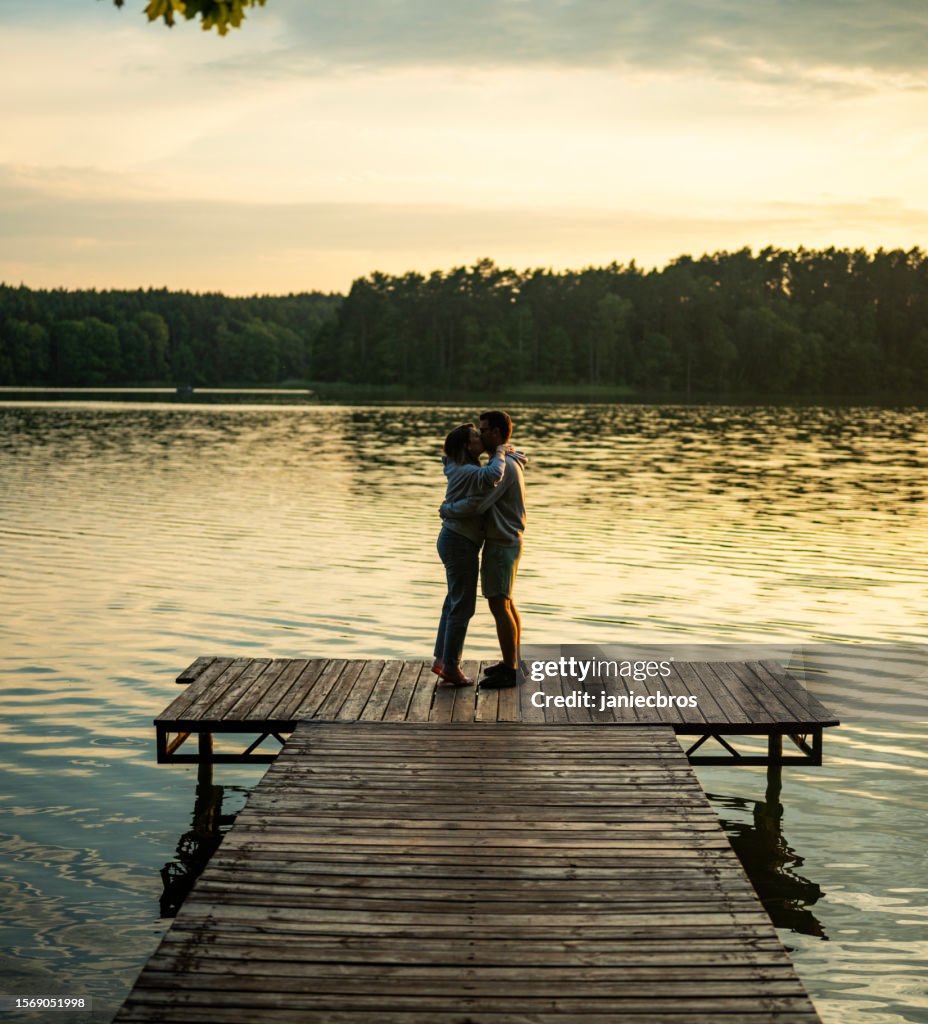 Romantic couple relaxing lying on the pier. Enjoying the scenery vertical image