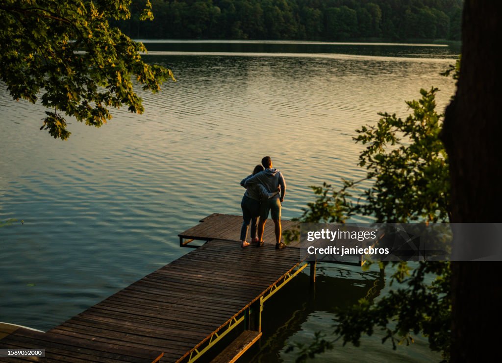 Romantic couple relaxing lying on the pier. Enjoying the scenery of water