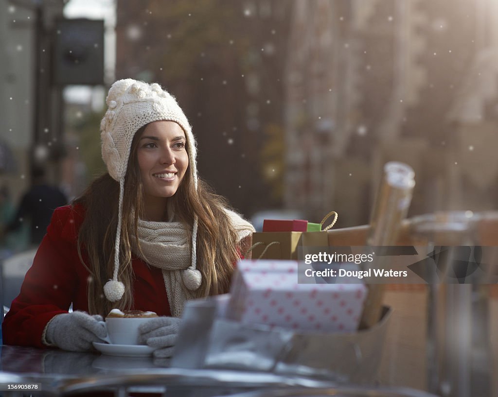 Christmas shopper with coffee and presents in snow
