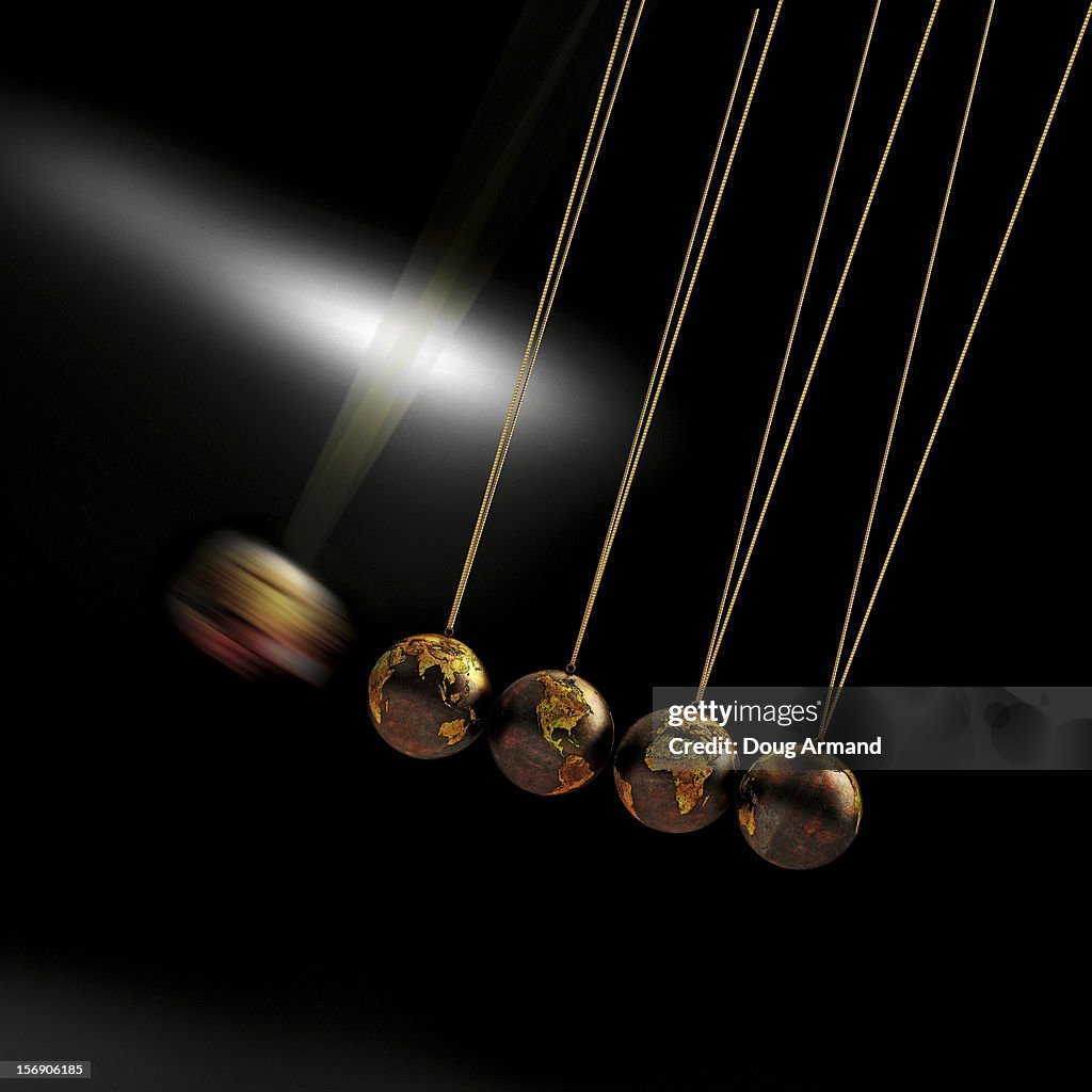 Newtons Cradle made of metal Earth globes