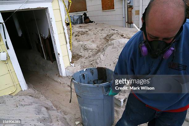 Mark Fischetti pulls a barrel of trash out of a home damaged by Superstorm Sandy, on November 24, 2012 in Seaside Heights, New Jersey. New Jersey...