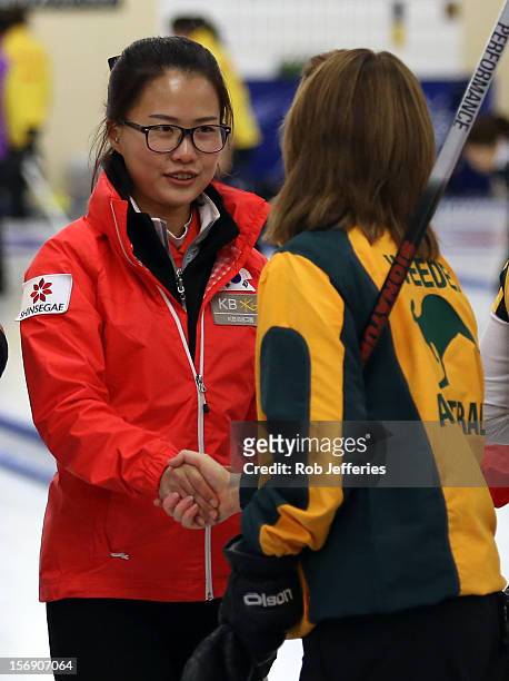 Eun-Jung Kim of Korea is congratulated by Laurie Weeden of Australia after their win to claim third at the Pacific Asia 2012 Curling Championship at...