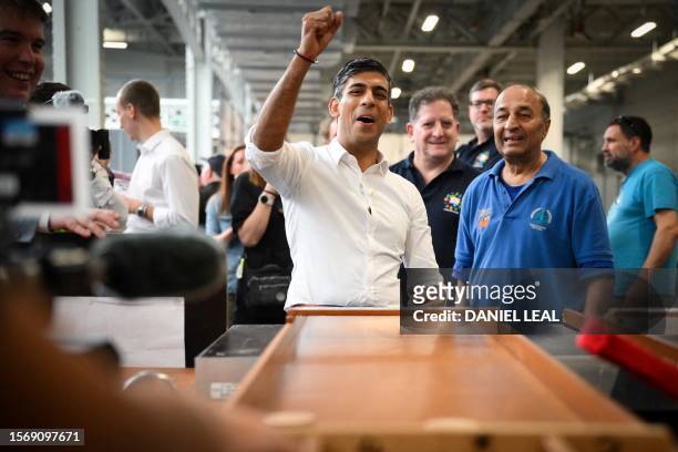 Britain's Prime Minister Rishi Sunak reacts as he plays a pub game during a visit to the Great British Beer Festival in west London on August 1, 2023.