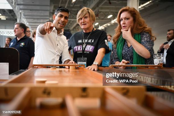 Britain's Prime Minister Rishi Sunak reacts as he plays a pub game during a visit to the Great British Beer Festival on August 1, 2023 in London,...