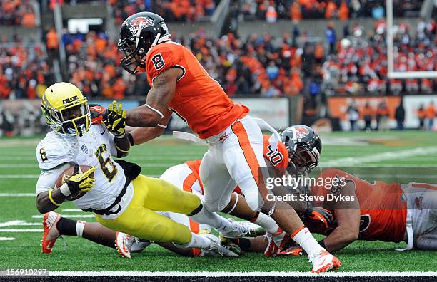 Running back De'Anthony Thomas of the Oregon Ducks is hit by safety Tyrequek Zimmerman of the Oregon State Beavers as he runs the ball in for a...