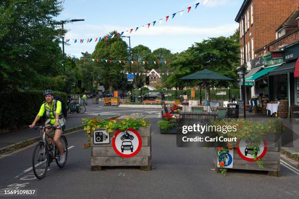 Cyclist passes planters blocking a road for cars in a low traffic neighbourhood on August 1, 2023 in London, England. Prime Minister Rishi Sunak has...