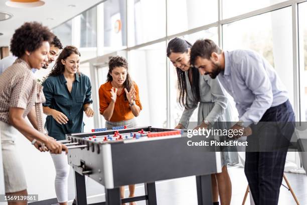 businesspeople playing table football at office - table football stock pictures, royalty-free photos & images
