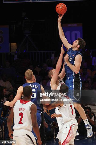 Ryan Kelly of the Duke Blue Devils shoots over Luke Hancock of the Louisville Cardinals during the Battle 4 Atlantis tournament at Atlantis Resort...