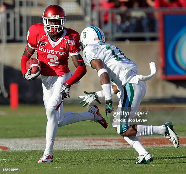 Deontay Greenberry of the Houston Cougars looks for room to run by Jordan Batiste of the Tulane Green Wave at Robertson Stadium on November 24, 2012...