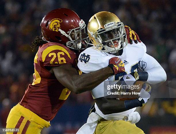 Cierre Wood of the Notre Dame Fighting Irish protects the ball as he is tackled by Josh Shaw of the USC Trojans during a 22-13 Notre Dame win at Los...