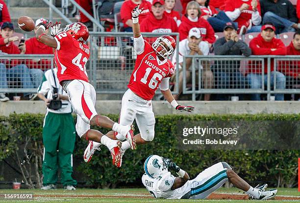 Phillip Steward and Adrian McDonald of the Houston Cougars attempt to intercept a pass as Ryan Grant of the Tulane Green Wave falls down at Robertson...