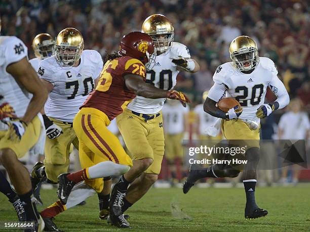 Cierre Wood of the Notre Dame Fighting Irish carries the ball as he gets a block from Tyler Eifert on Josh Shaw of the USC Trojans during a 22-13...