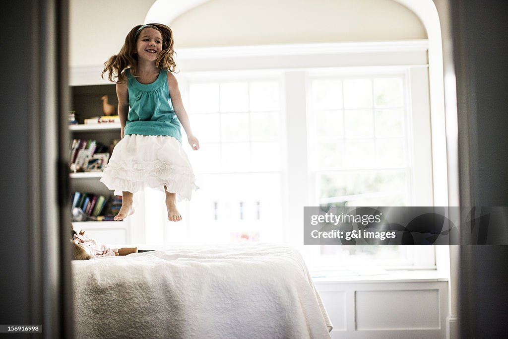 Girl (6yrs) jumping on bed