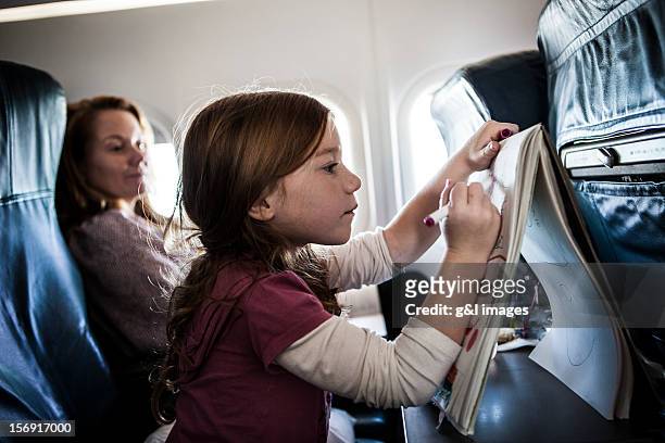 girl (6yrs) on airplane, drawing on tablet - kind flugzeug stock-fotos und bilder
