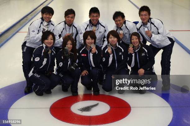 The Japan women and men pose for a photo after winning silver during the Pacific Asia 2012 Curling Championship at the Naseby Indoor Curling Arena on...