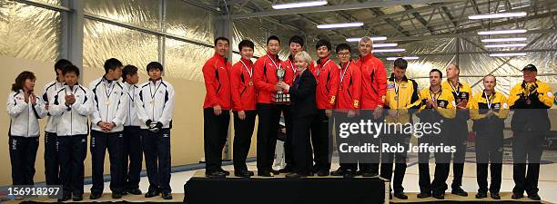The Japan , China and Australia mens teams pose for a photo during the Pacific Asia 2012 Curling Championship at the Naseby Indoor Curling Arena on...