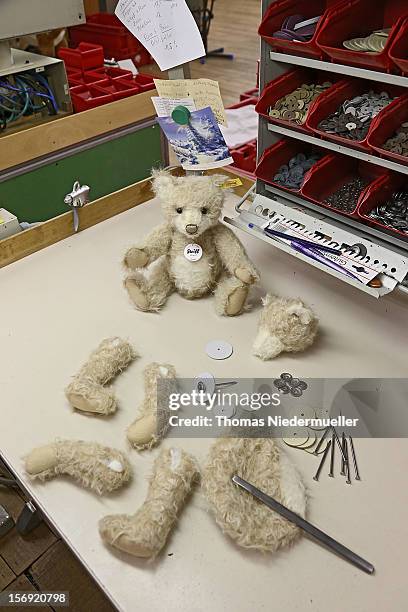 Teddy bear and the limbs and torso of an unassembled bear sit on a table at the Steiff stuffed toy factory on November 23, 2012 in Giengen an der...