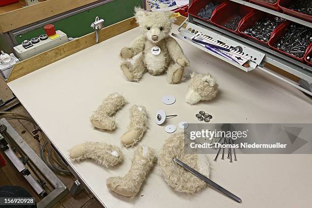 Teddy bear and the limbs and torso of an unassembled bear sit on a table at the Steiff stuffed toy factory on November 23, 2012 in Giengen an der...