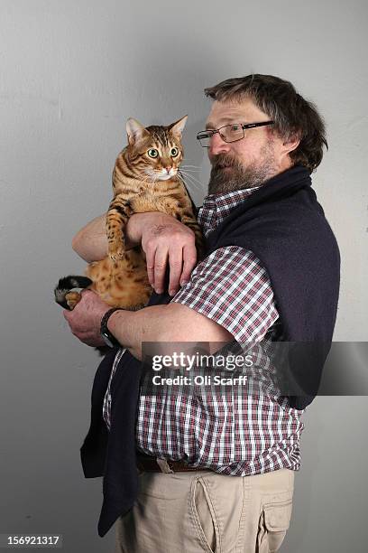 Charles Wilson poses for a photograph with his Brown Spotted Bengal cat named 'Lacemoat-Rocknrola' after being exhibited at the Governing Council of...