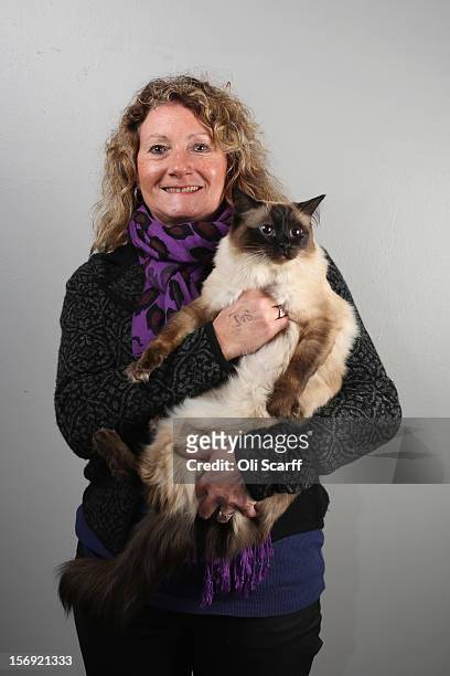 Jackie Lawes poses for a photograph with her cat named 'Tagula Black Velvet' after being exhibited at the Governing Council of the Cat Fancy's...