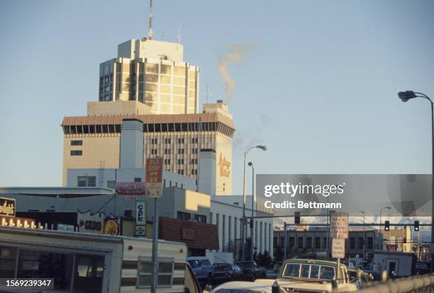 View of a street in Anchorage with the Anchorage Westward hotel on the left, Alaska, December 1978. The taller building is the hotel's East Tower.
