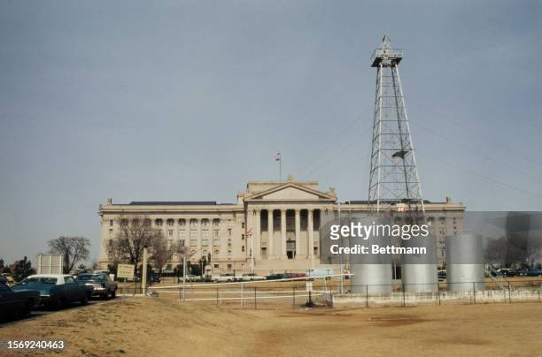 Exterior view of the Oklahoma State Capitol building with oil rig, Oklahoma City, 1975.
