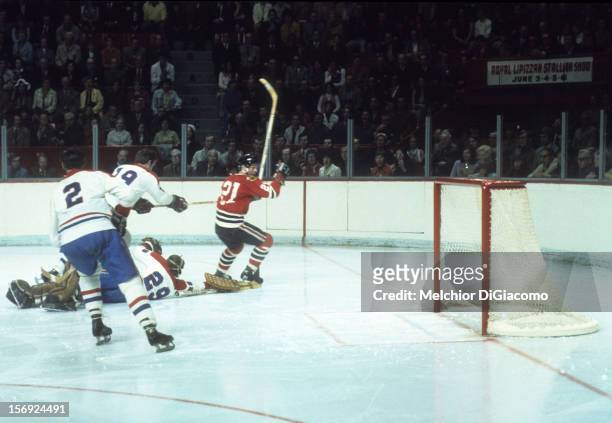 Stan Mikita of the Chicago Blackhawks skates on the ice as Terry Harper, goalie Ken Dryden and Jacques Laperriere of the Montreal Canadiens defend...