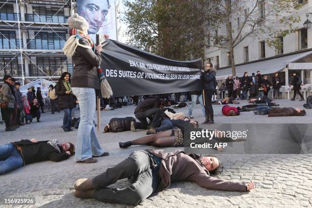 French feminists of the "Ni Putes, Ni Soumises" movement lie on the ground to simulate agressions on November 25, 2012 in front of the Centre...